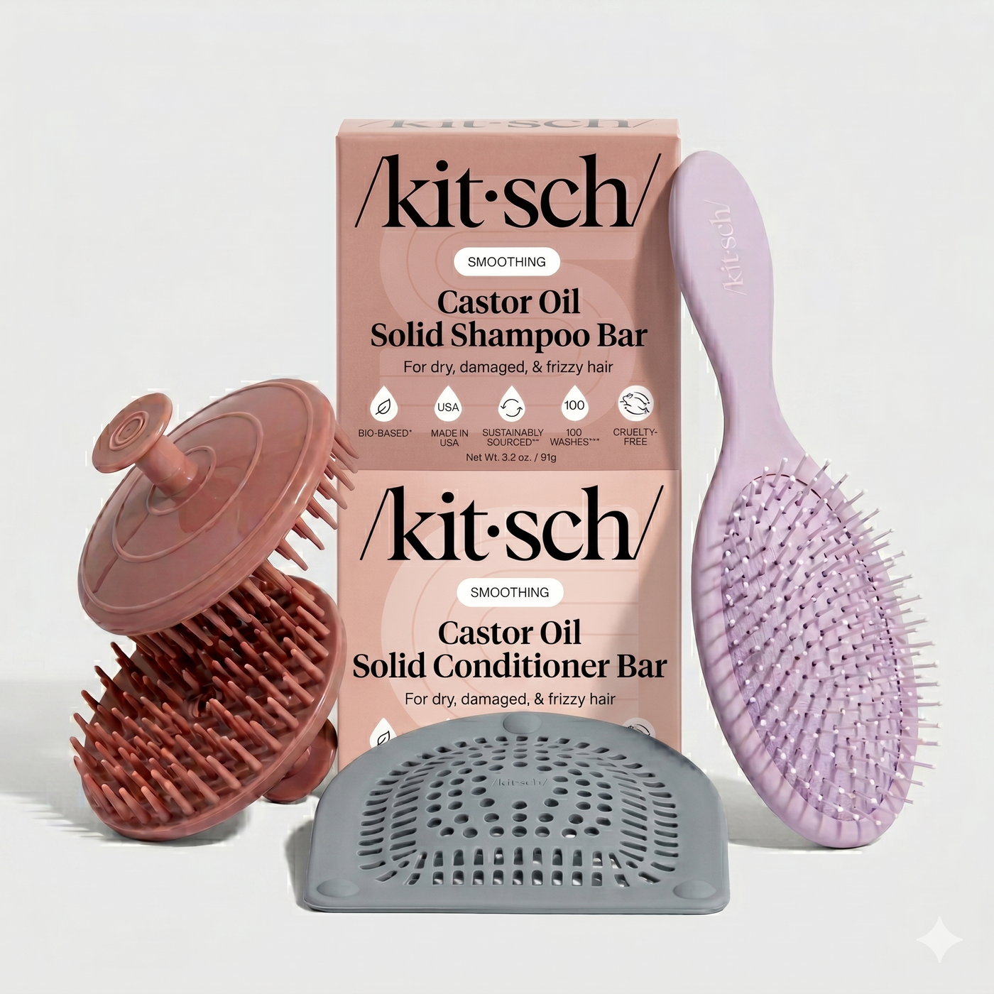 Kitsch Smoothing Castor Oil Solid Shampoo Bar and Conditioner Bar set for dry, damaged, and frizzy hair, shown with a terracotta silicone scalp massager, lavender detangling brush, and gray silicone soap dish.